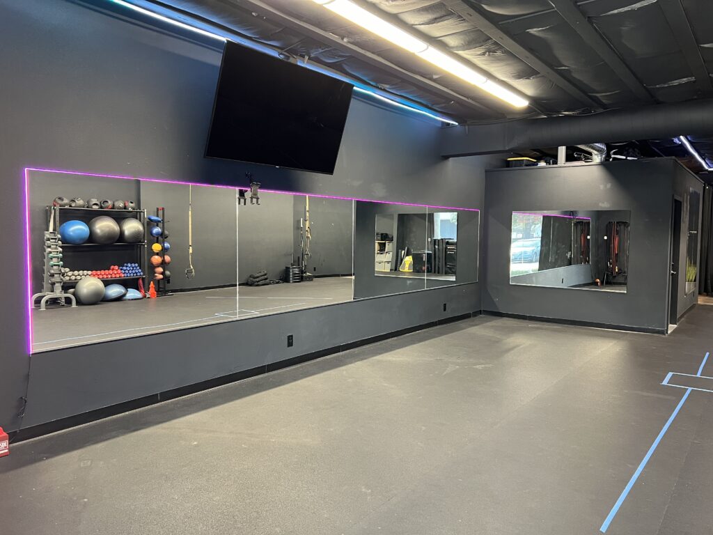 Well-equipped rental studio featuring floor mats, free weights, and resistance bands in a vibrant gym setting.