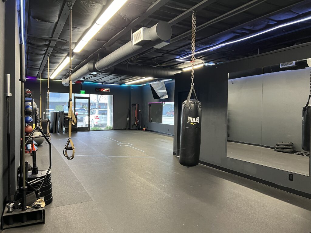 Well-equipped rental studio featuring floor mats, free weights, and resistance bands in a vibrant gym setting.