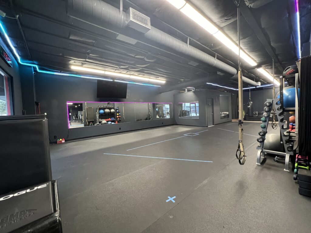 Well-equipped rental studio featuring floor mats, free weights, and resistance bands in a vibrant gym setting.