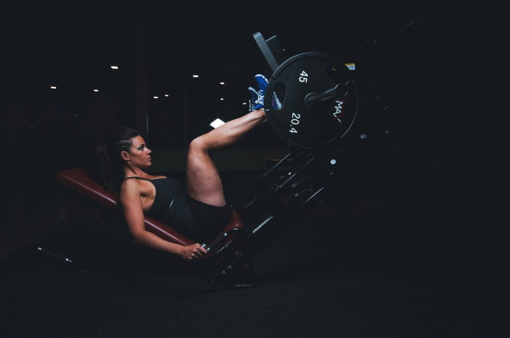 Strength in motion: A woman pushes against the leg press machine's platform, demonstrating dedication to lower-body strength training.