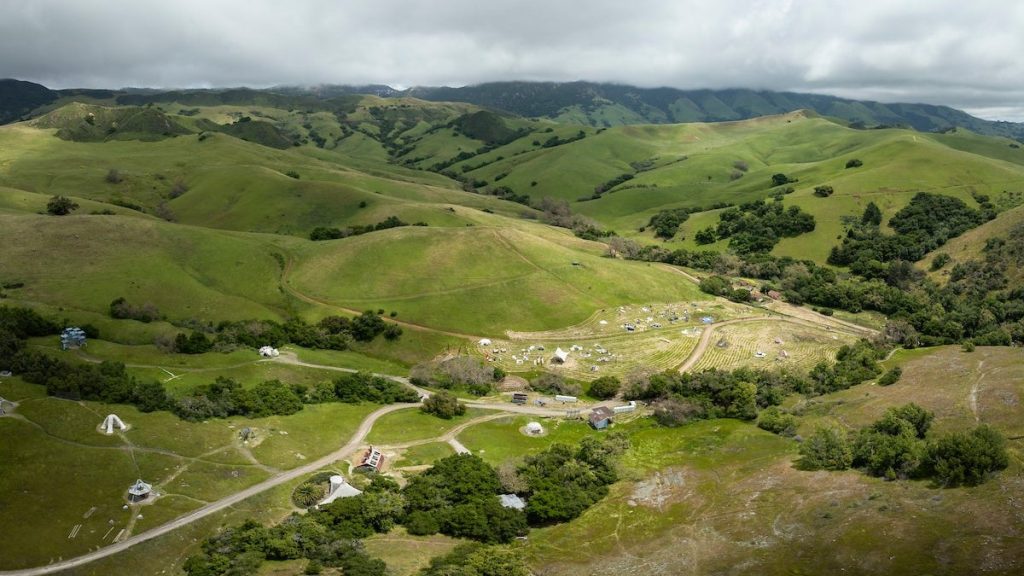 Aerial view of Poly Canyon on Cal Poly campus surrounded by rolling green hills in San Luis Obispo