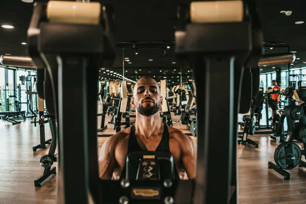 Man performing a chest press machine exercise during an upper body strength training workout