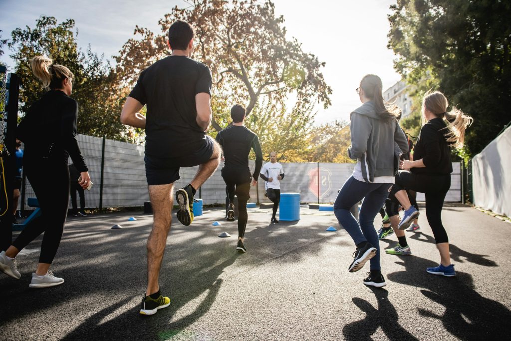 Group of athletes training outdoors on a sunny day, highlighting the increased hydration demands of summer exercise