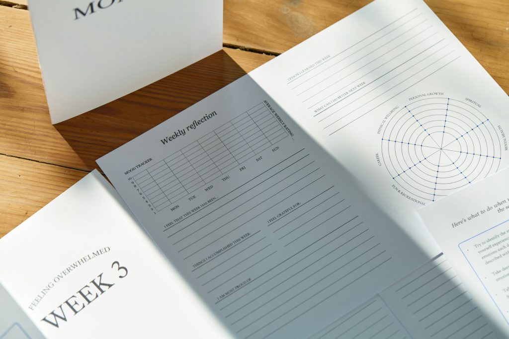 Person writing notes in an open journal to track workout progress and goals
